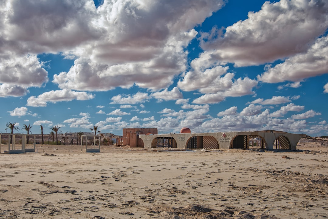 Arid landscape with arched structures under cloudy sky